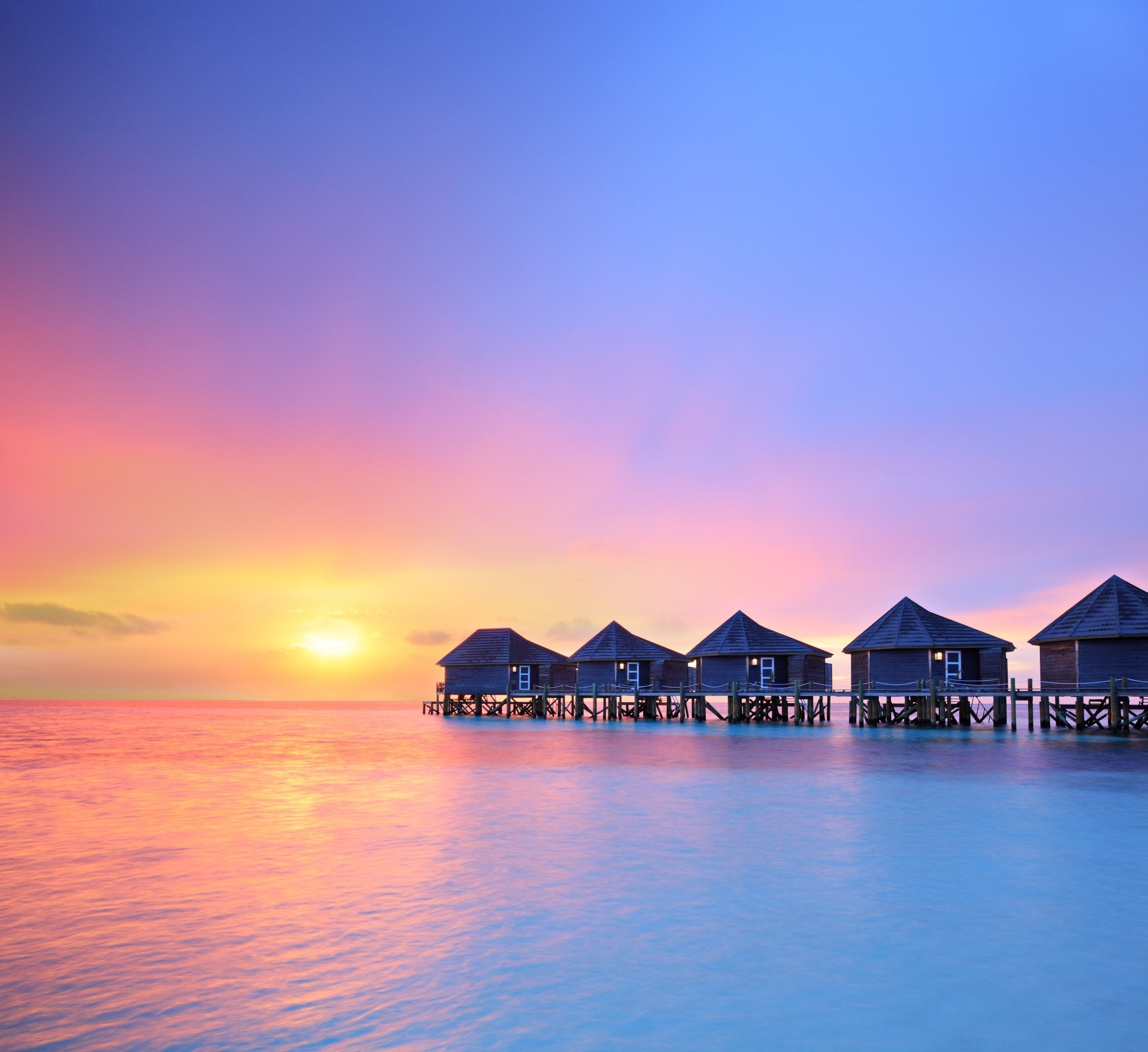 Sunset on a Maldives island and water villas